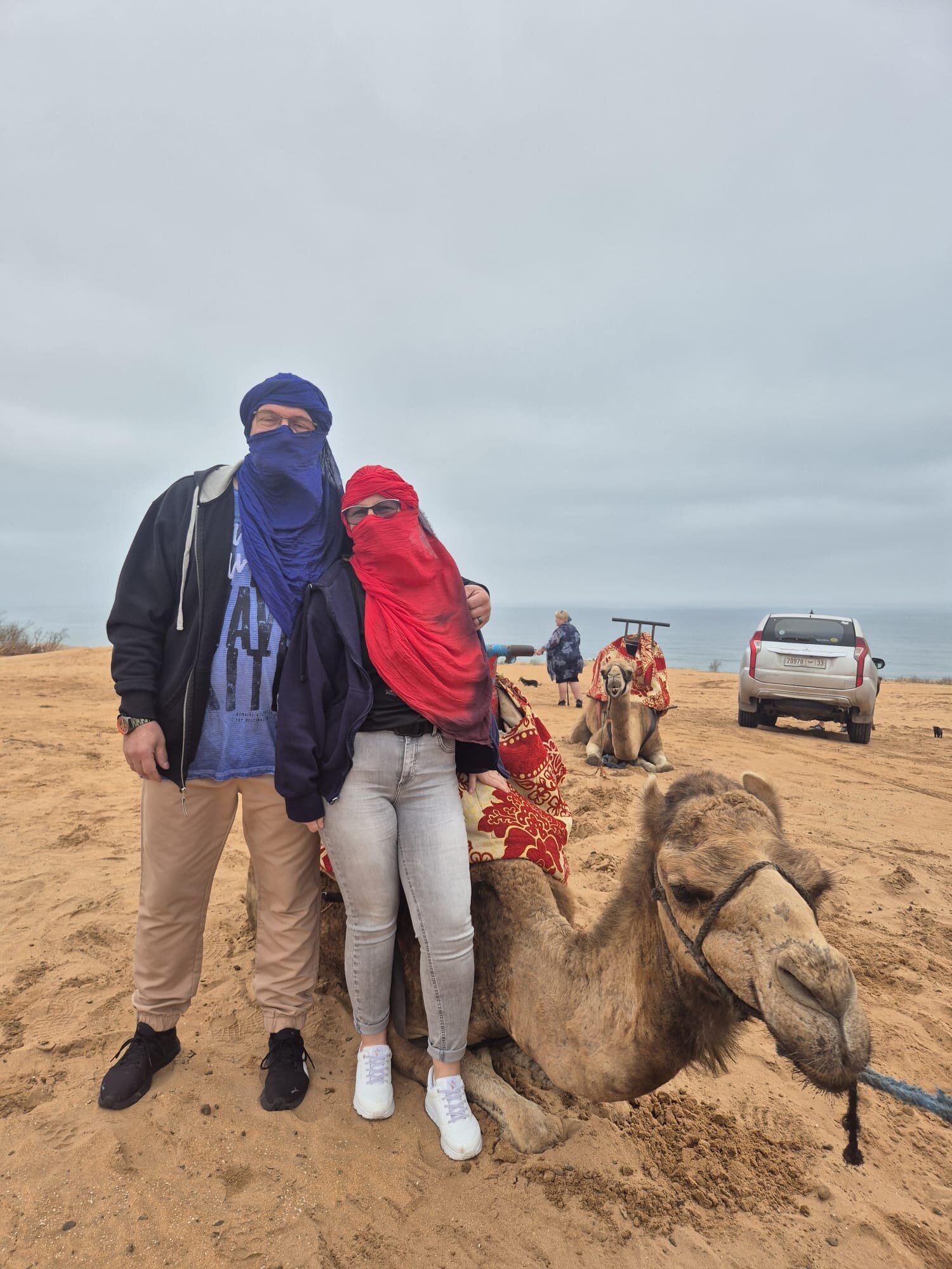 Guests with a camel in the little Sahara at the end of the day